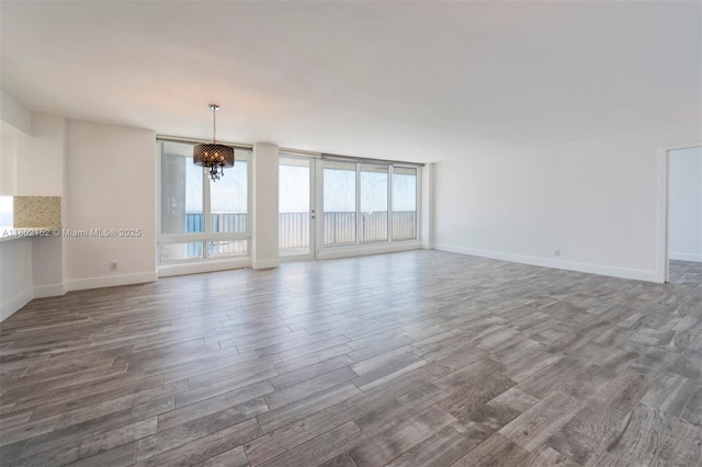 4280 Galt Ocean Dr Unit 23A, Fort Lauderdale, FL 33308 - unfurnished living room featuring a chandelier, wood finished floors, and baseboards