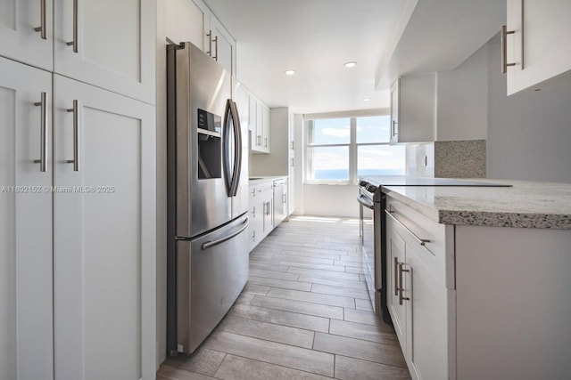 4280 Galt Ocean Dr Unit 23A, Fort Lauderdale, FL 33308 - kitchen featuring stainless steel appliances, wood finish floors, white cabinetry, recessed lighting, and light stone countertops