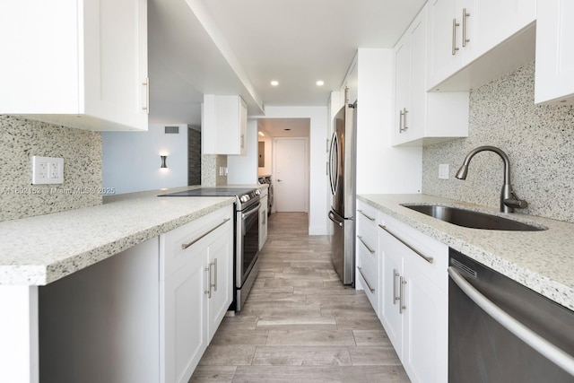 4280 Galt Ocean Dr Unit 23A, Fort Lauderdale, FL 33308 - kitchen featuring stainless steel appliances, a sink, backsplash, white cabinets, and light wood-style floors
