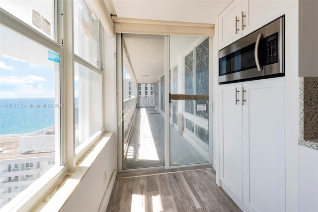 4280 Galt Ocean Dr Unit 23A, Fort Lauderdale, FL 33308 - unfurnished sunroom featuring a water view, wood finished floors, and plenty of natural light