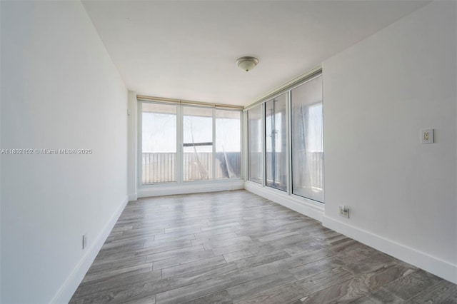 4280 Galt Ocean Dr Unit 23A, Fort Lauderdale, FL 33308 - spare room with healthy amount of natural light, wood finished floors, and baseboards