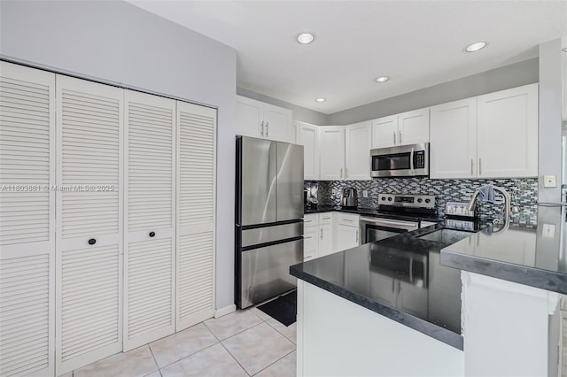 11832 Royal Palm Blvd, Coral Springs, FL 33065 - kitchen with appliances with stainless steel finishes, a sink, a peninsula, light tile patterned floors, and white cabinetry