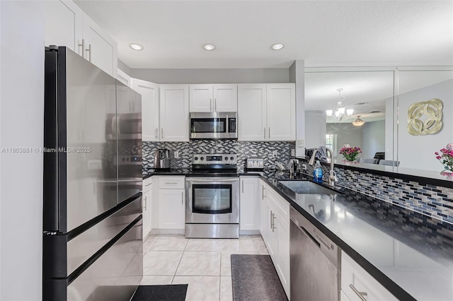11832 Royal Palm Blvd, Coral Springs, FL 33065 - kitchen with stainless steel appliances, a sink, light tile patterned flooring, dark countertops, and decorative backsplash