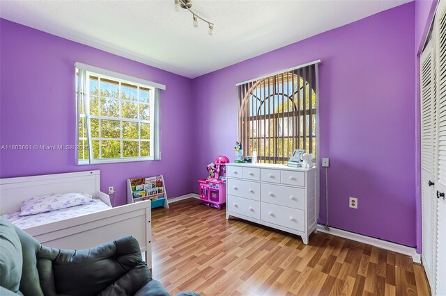 11832 Royal Palm Blvd, Coral Springs, FL 33065 - bedroom featuring wood finished floors, rail lighting, baseboards, and a closet