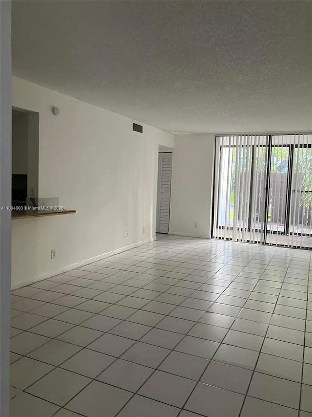 213 Lake Pointe Dr Unit 112, Oakland Park, FL 33309 - tiled empty room featuring baseboards and a textured ceiling