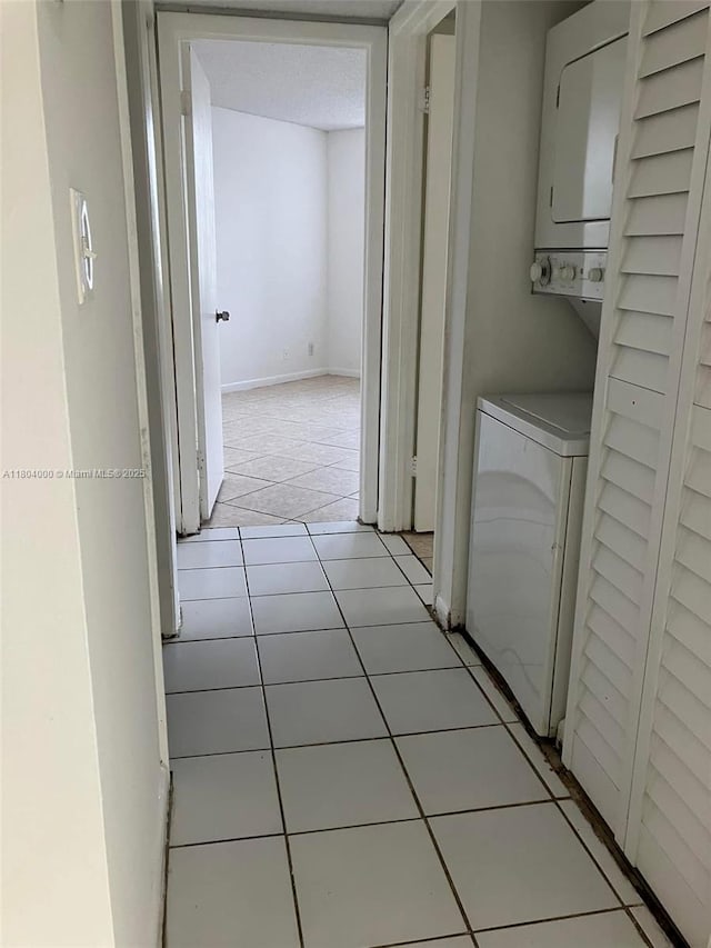213 Lake Pointe Dr Unit 112, Oakland Park, FL 33309 - washroom featuring stacked washer and clothes dryer and tile patterned floors