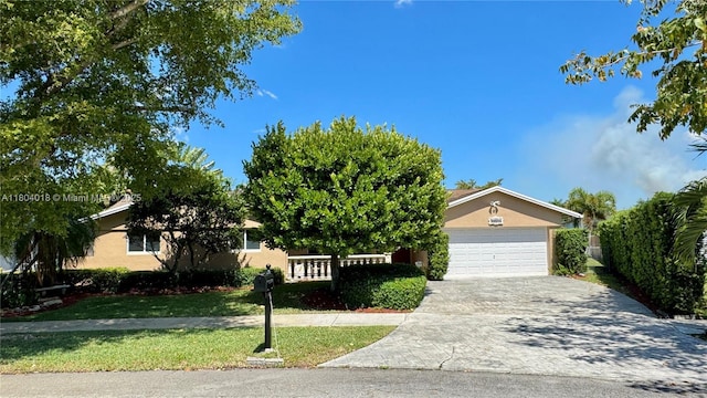 10715 SW 139th Ct, Miami, FL 33186 - obstructed view of property with stucco siding, a garage, driveway, and a front lawn