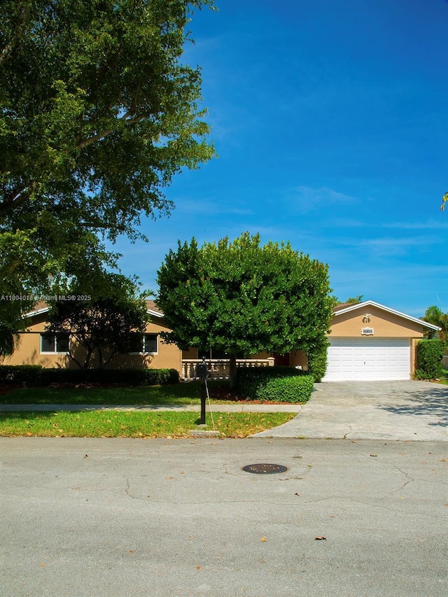 10715 SW 139th Ct, Miami, FL 33186 - obstructed view of property featuring driveway, a garage, and stucco siding
