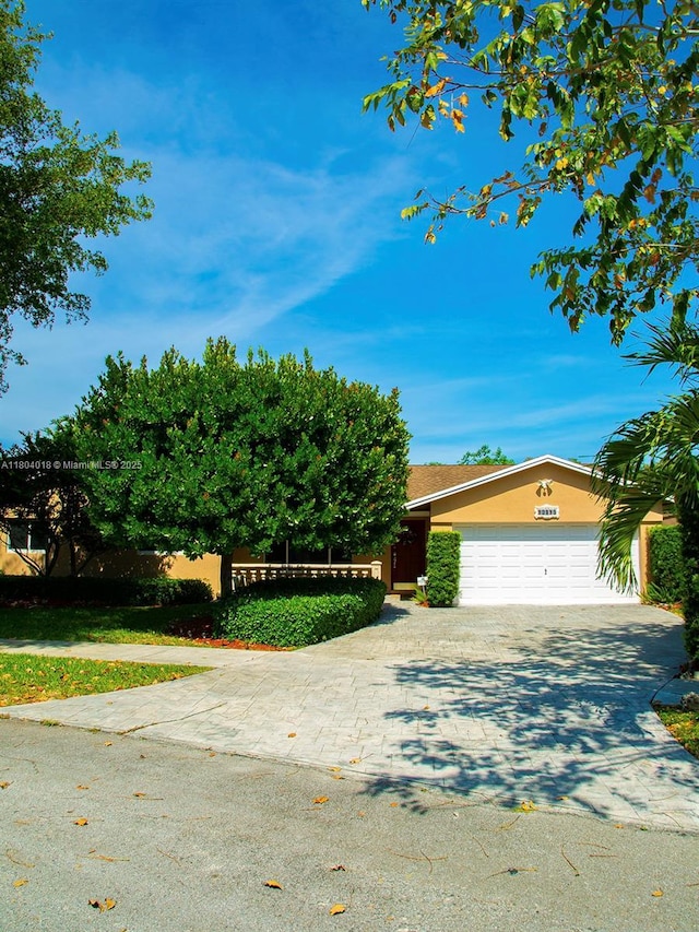 10715 SW 139th Ct, Miami, FL 33186 - obstructed view of property with concrete driveway, an attached garage, and stucco siding