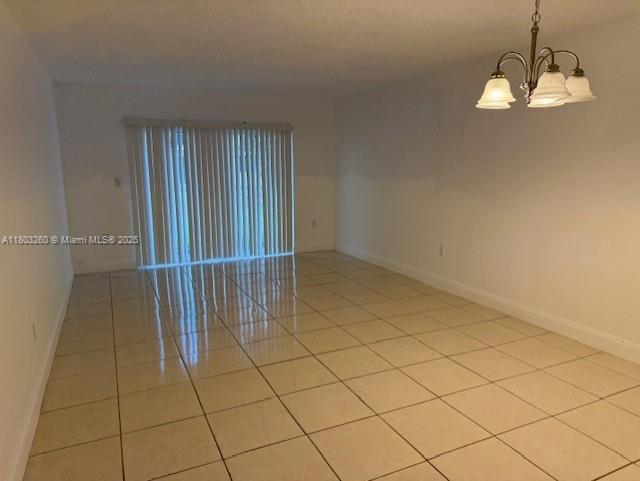 505 NW 177th St Unit 136, Miami Gardens, FL 33169 - empty room with a chandelier, baseboards, and light tile patterned floors
