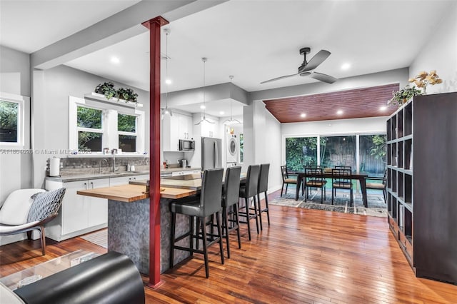1631 SW 11th St, Miami, FL 33135 - kitchen with stacked washer / dryer, wooden counters, white cabinetry, stainless steel appliances, and a ceiling fan