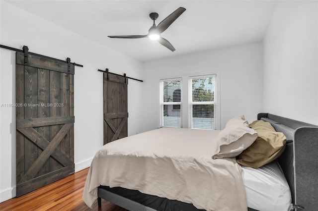 1631 SW 11th St, Miami, FL 33135 - bedroom featuring a barn door, wood finished floors, and a ceiling fan