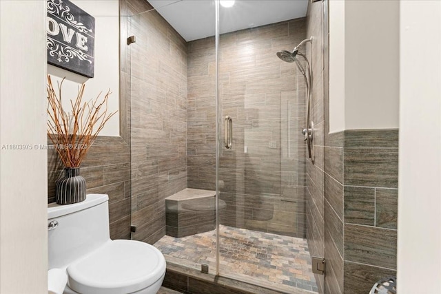 1150 NW 99th Ave Unit 69, Pembroke Pines, FL 33024 - full bathroom featuring tile walls, a shower stall, toilet, and a wainscoted wall