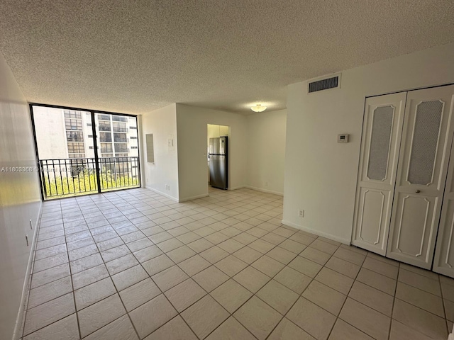 16919 N Bay Rd Unit 617, Sunny Isles Beach, FL 33160 - spare room featuring light tile patterned floors, a textured ceiling, baseboards, and expansive windows