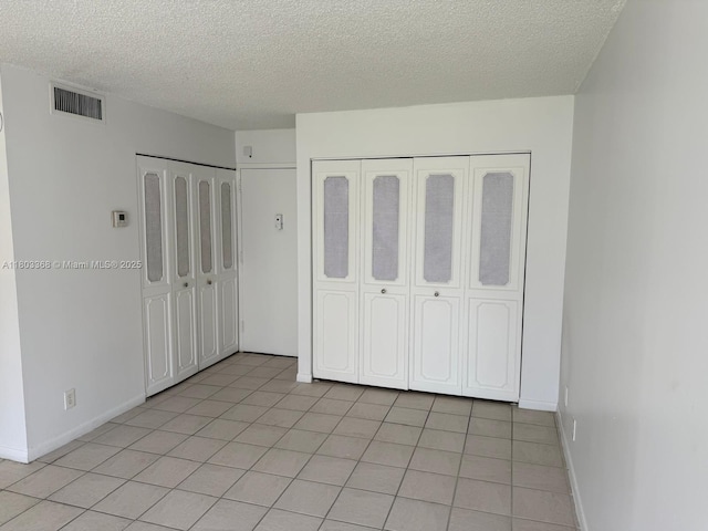 16919 N Bay Rd Unit 617, Sunny Isles Beach, FL 33160 - unfurnished bedroom with a textured ceiling, baseboards, and light tile patterned floors