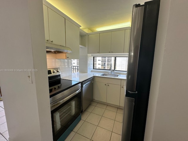16919 N Bay Rd Unit 617, Sunny Isles Beach, FL 33160 - kitchen with stainless steel appliances, a sink, under cabinet range hood, light tile patterned floors, and light countertops