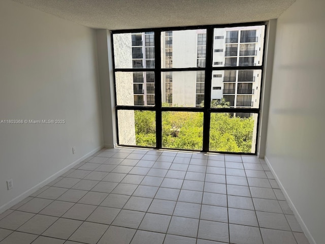 16919 N Bay Rd Unit 617, Sunny Isles Beach, FL 33160 - tiled spare room with a textured ceiling, plenty of natural light, expansive windows, and baseboards