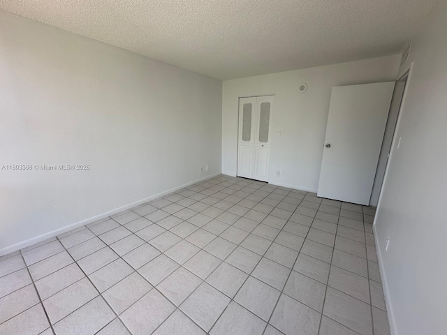 16919 N Bay Rd Unit 617, Sunny Isles Beach, FL 33160 - empty room with a textured ceiling, baseboards, and light tile patterned floors