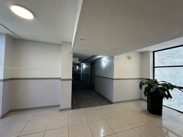 16919 N Bay Rd Unit 617, Sunny Isles Beach, FL 33160 - hallway with baseboards, a textured ceiling, and light tile patterned floors