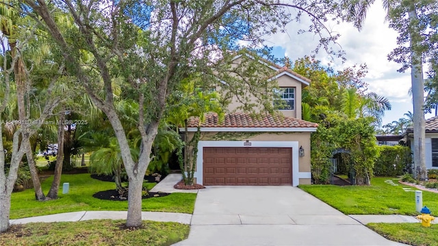 mediterranean / spanish home with concrete driveway, stucco siding, a garage, and a front yard