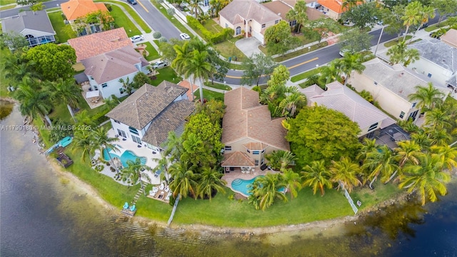 aerial view of residential area with a pool and a large body of water