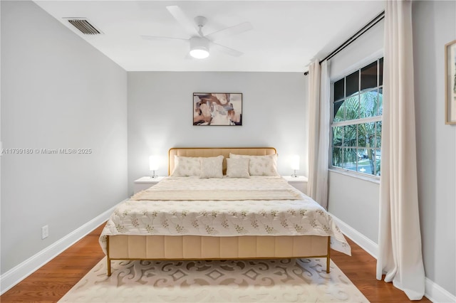 bedroom featuring wood finished floors, baseboards, and ceiling fan