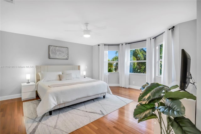 bedroom with baseboards, wood finished floors, and a ceiling fan