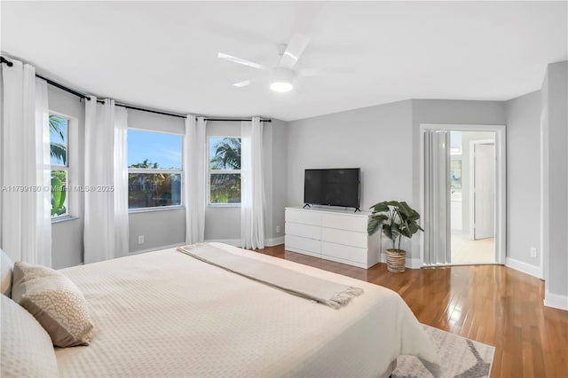 bedroom featuring wood finished floors, baseboards, and a ceiling fan