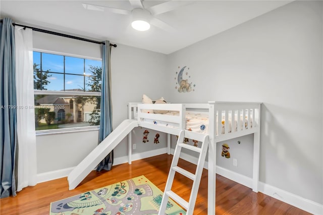 bedroom with wood finished floors, baseboards, and a ceiling fan