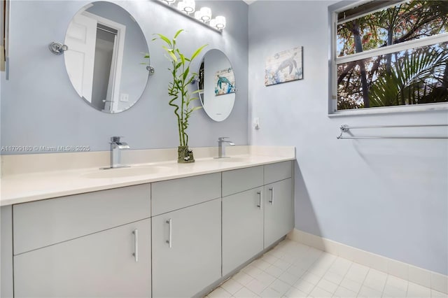 full bath with double vanity, baseboards, and tile patterned flooring