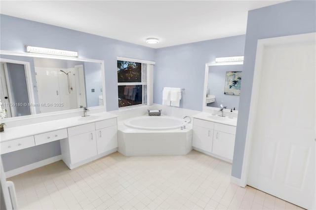 full bath featuring a garden tub, two vanities, a shower stall, and tile patterned flooring