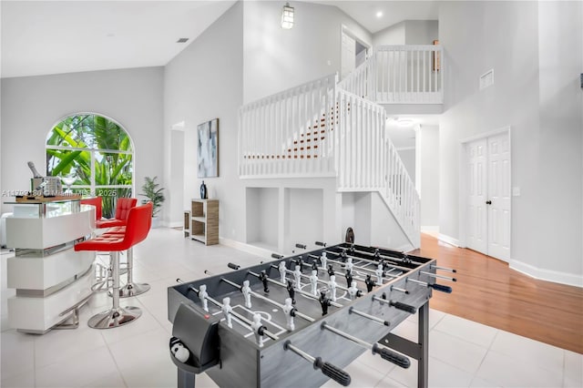 playroom featuring high vaulted ceiling, baseboards, and tile patterned floors