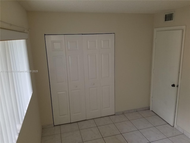 unfurnished bedroom with light tile patterned floors and a closet
