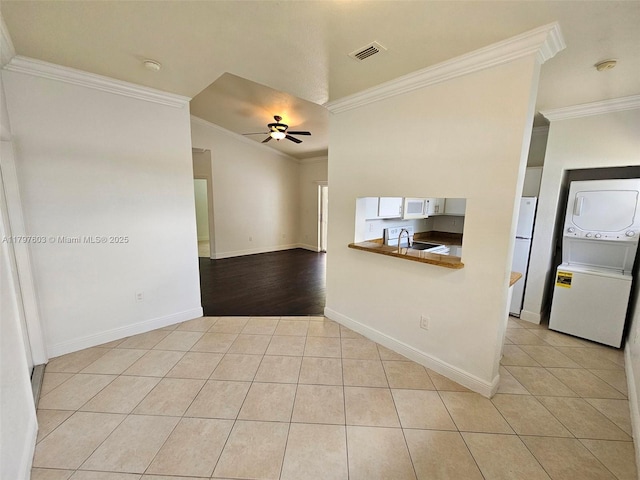 2151 NW 96th Ter Unit 15L, Pembroke Pines, FL 33024 - empty room featuring stacked washing machine and dryer, light tile patterned floors, a ceiling fan, and ornamental molding