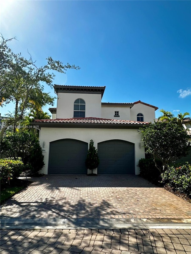 822 E Spinnaker Dr E, Hollywood, FL 33019 - mediterranean / spanish house featuring decorative driveway, stucco siding, and a garage