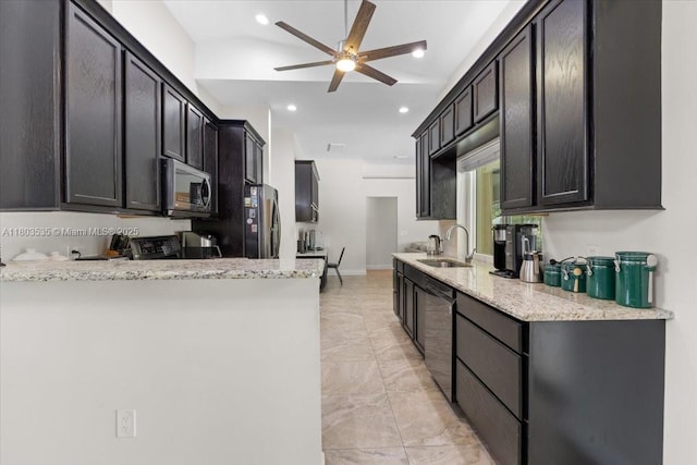 112 SW N Danville Cir, Port St Lucie, FL 34953 - kitchen with stainless steel appliances, a sink, ceiling fan, light stone countertops, and a peninsula