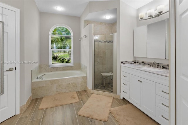112 SW N Danville Cir, Port St Lucie, FL 34953 - full bathroom featuring a shower stall, a garden tub, vanity, and wood finished floors