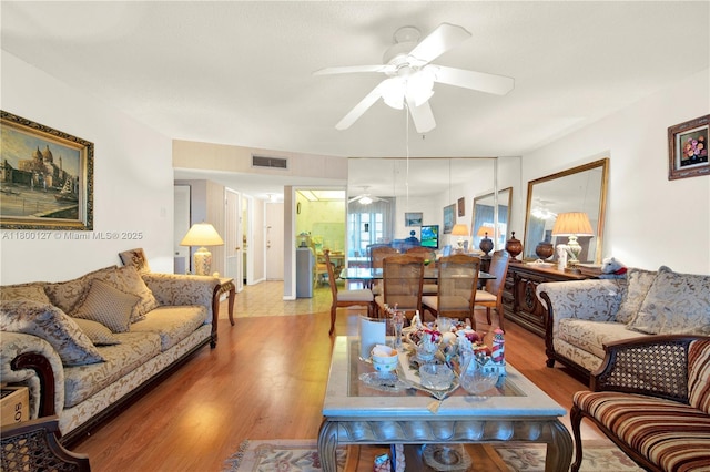 living area featuring ceiling fan and wood finished floors