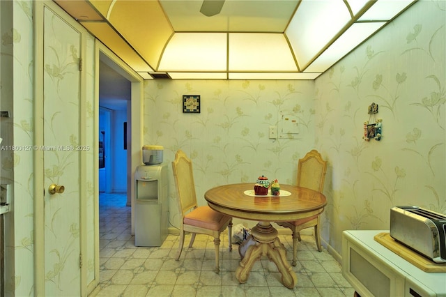 dining room featuring light flooring and wallpapered walls