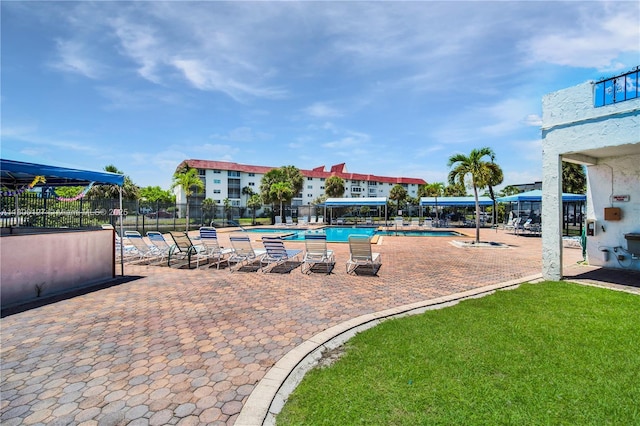community pool with fence and a patio area