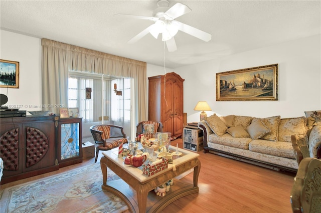 living room featuring ceiling fan and light wood finished floors