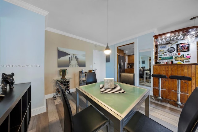 400 Kings Point Dr Unit 1021, Sunny Isles Beach, FL 33160 - dining room with ornamental molding, a bar, wood finished floors, and baseboards
