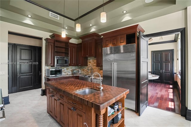 20508 SW 140th Ave, Miami, FL 33177 - kitchen with open shelves, built in appliances, dark countertops, a sink, and decorative backsplash