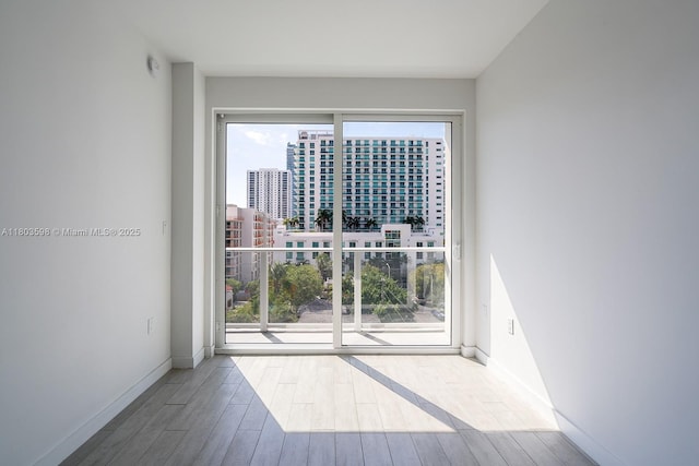 321 NE 26th St Unit 614, Miami, FL 33137 - empty room with wood finished floors, healthy amount of natural light, baseboards, and a view of city