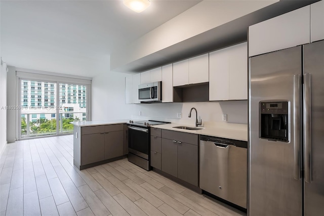 321 NE 26th St Unit 614, Miami, FL 33137 - kitchen with stainless steel appliances, light countertops, light wood-type flooring, a peninsula, and white cabinets