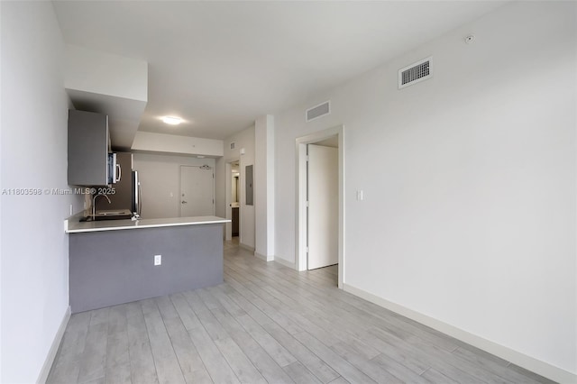 321 NE 26th St Unit 614, Miami, FL 33137 - kitchen with light wood-style flooring, light countertops, and a peninsula