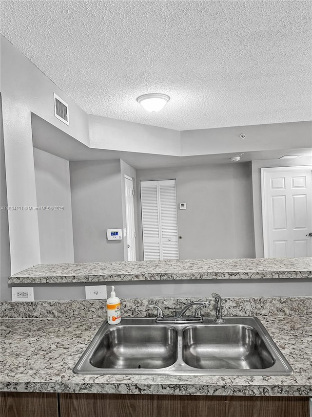 detailed view of a sink and a textured ceiling