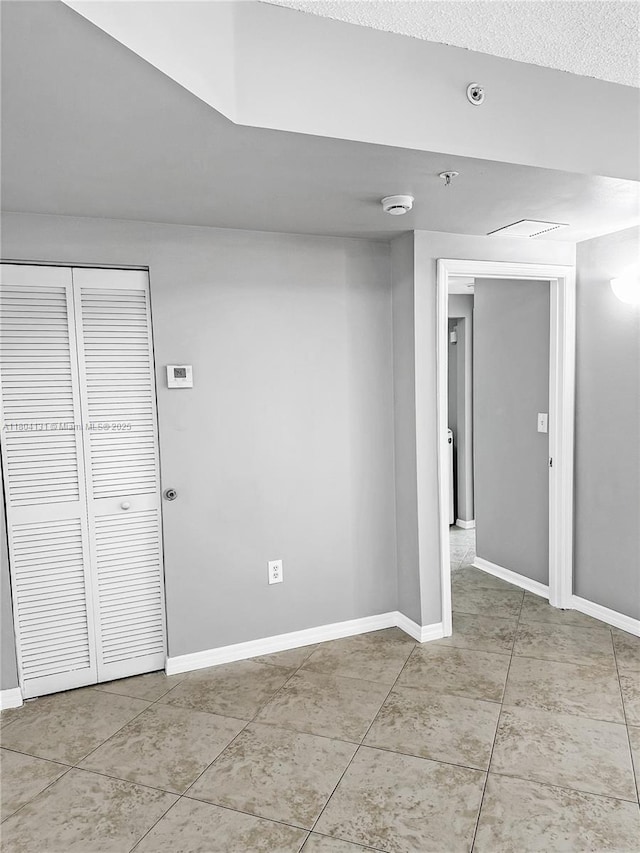 below grade area featuring baseboards and light tile patterned flooring