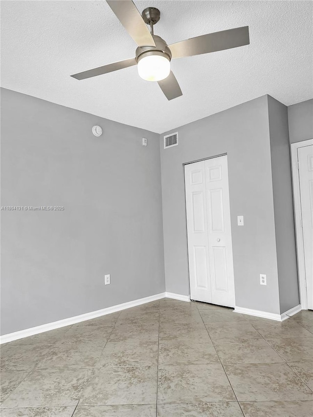 unfurnished bedroom featuring a textured ceiling, baseboards, and ceiling fan