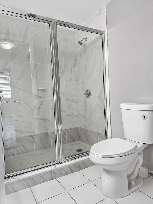 full bath featuring toilet, a stall shower, and baseboards